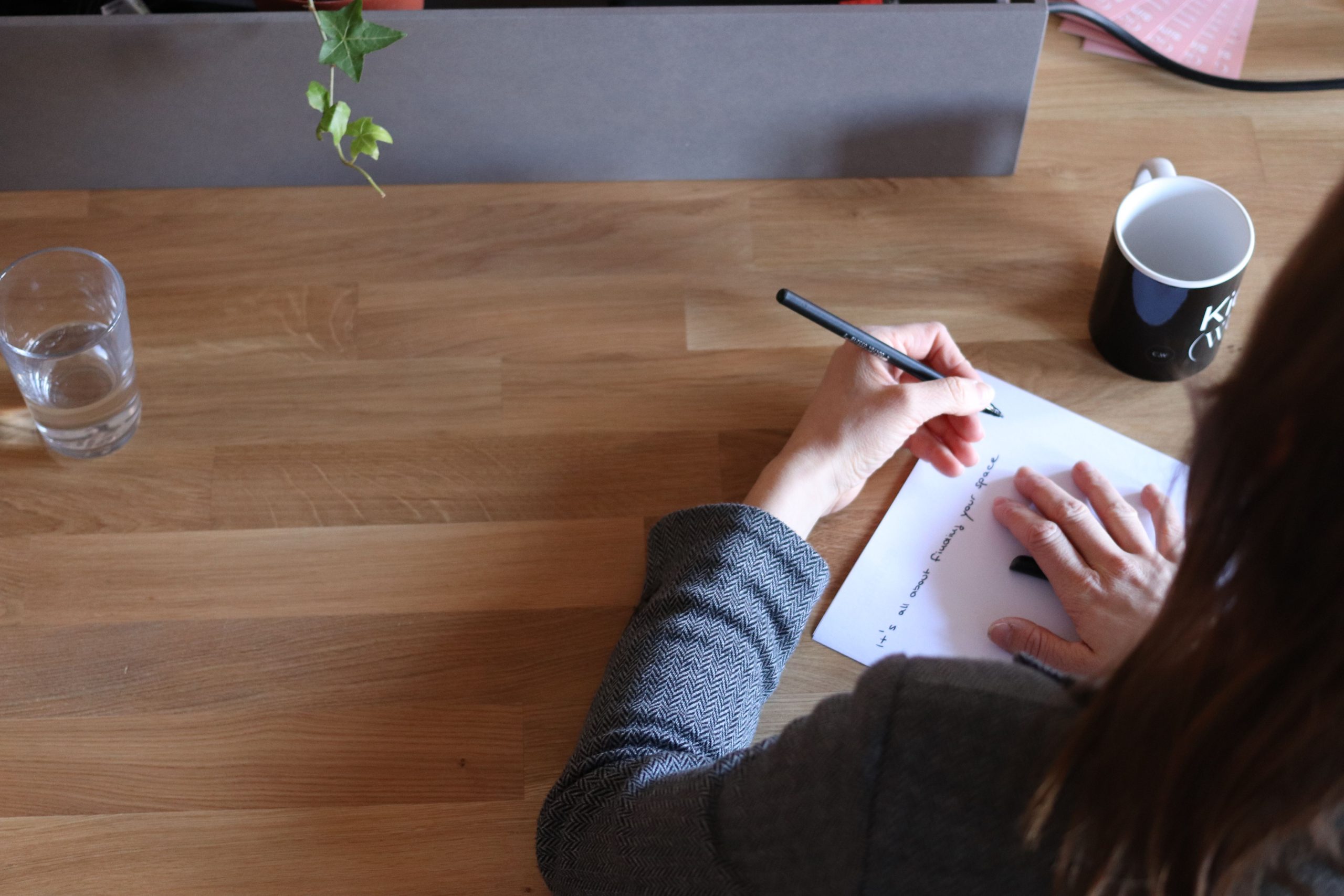 Femme prenant des notes à son bureau en bois
