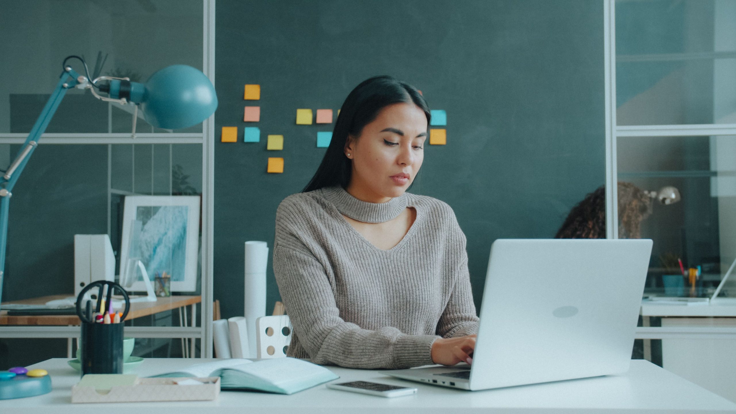 Femme utilisant un ordinateur portable dans un bureau moderne