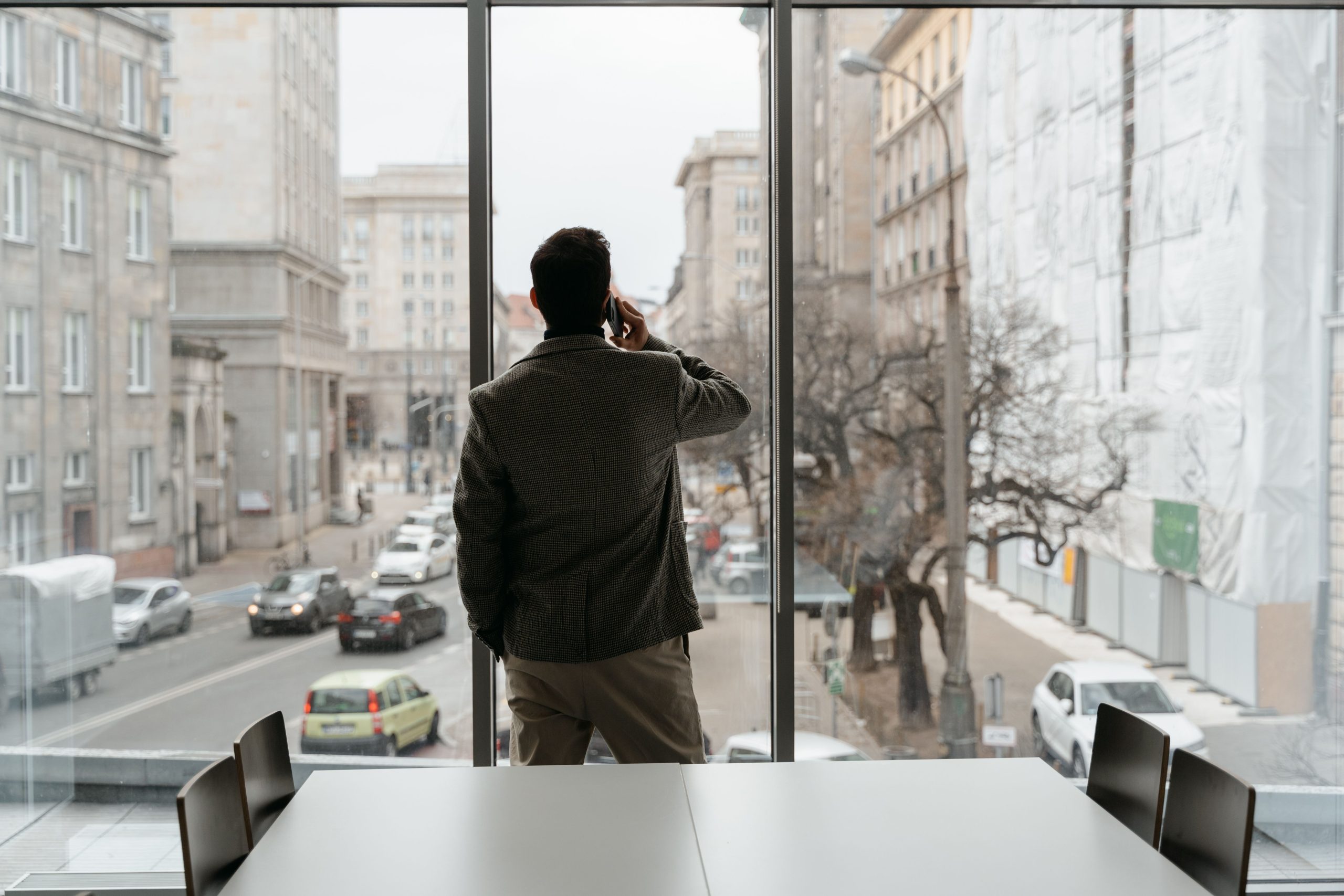 Homme passant un appel devant une fenêtre de bureau